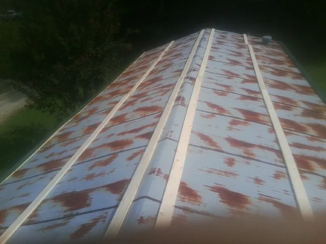 Rusted metal roof panels with new wood purlins before replacement — Storm Damage Roof Repair in Leavittsburg by Roofing Brothers