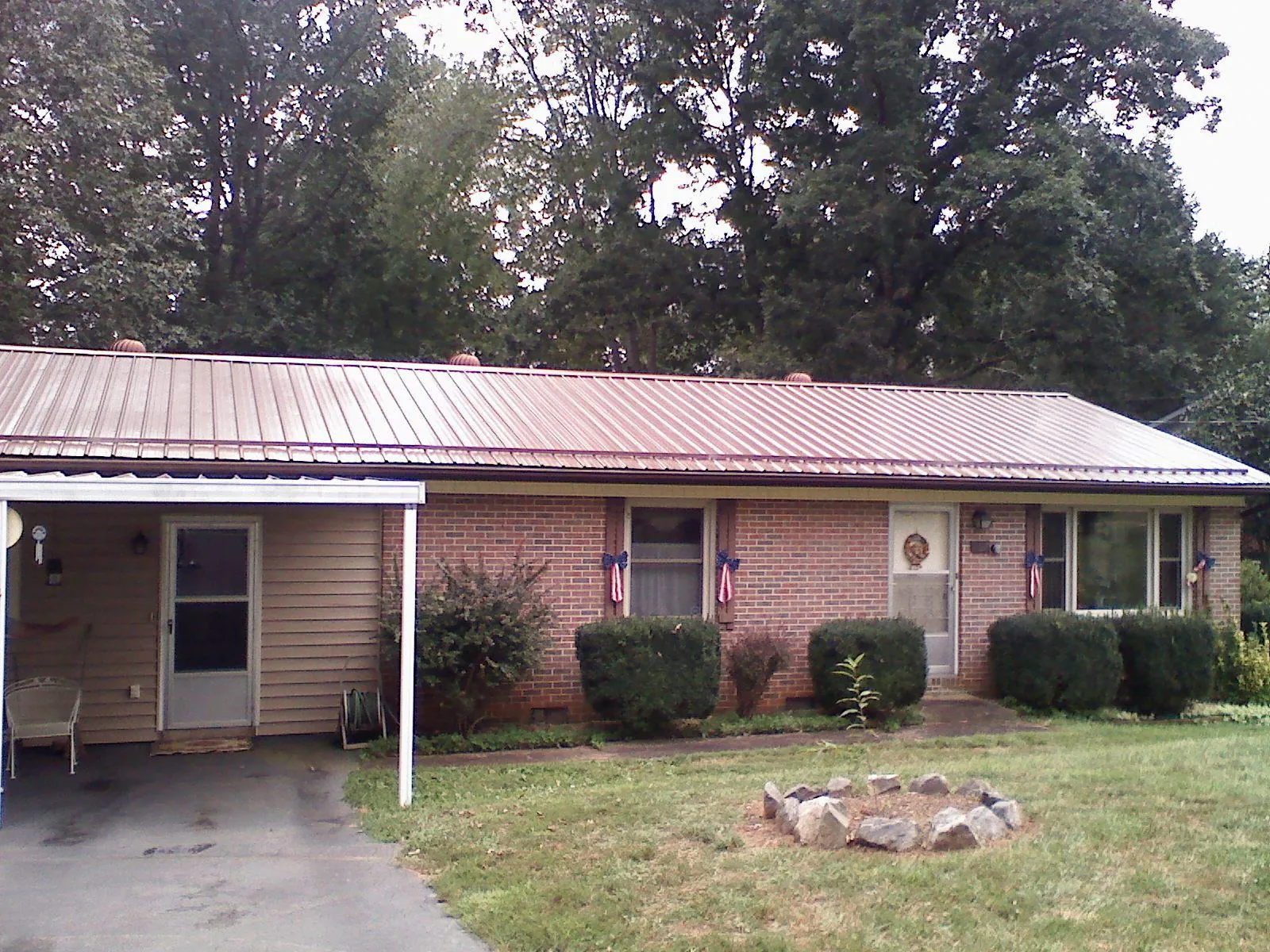 Bronze metal roof and carport on a brick ranch home — Roof Repair work by our crew in Leavittsburg